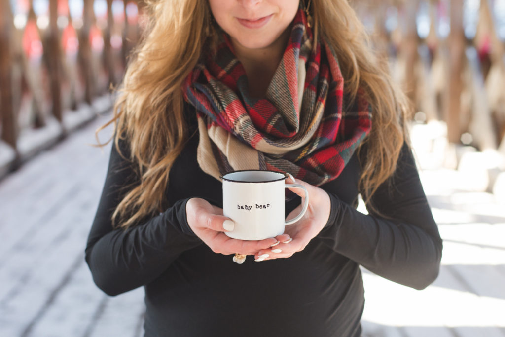 mother to be holding a coffee mug that says baby bear