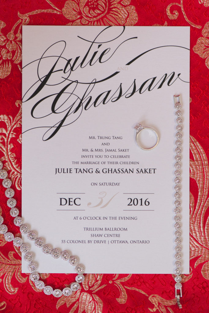 wedding invitation against red Chinese dress with engagement ring and jewellery
