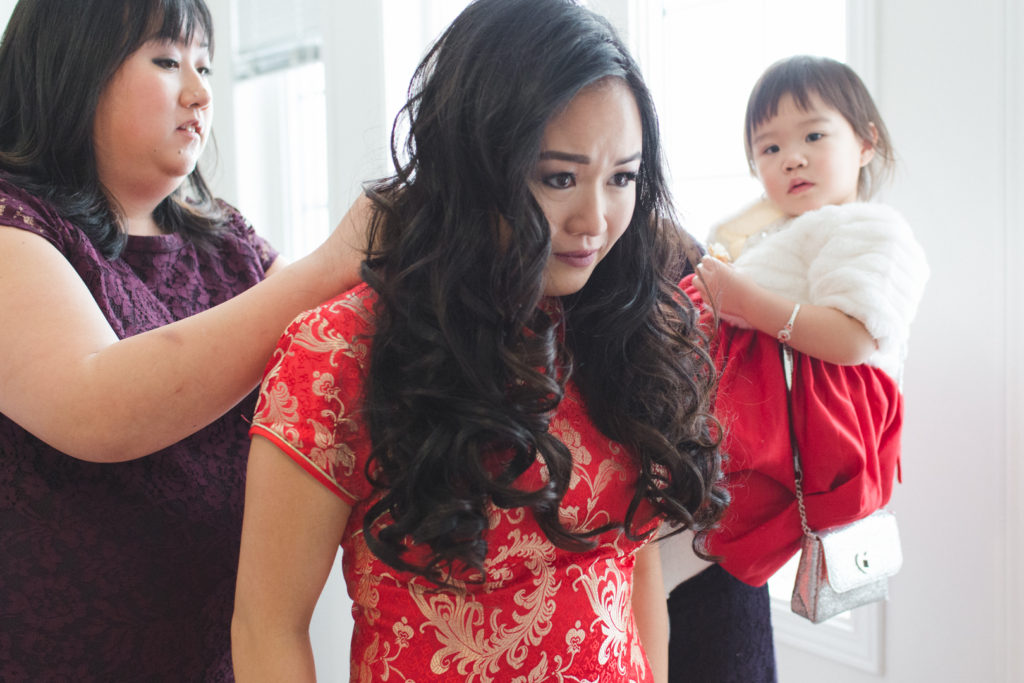 bride tearing up seeing herself in red Chinese wedding dress before tea ceremony