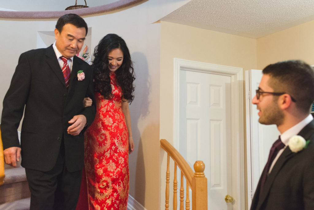 Bride and her father walking down the stairs towards the groom before Chinese tea ceremony