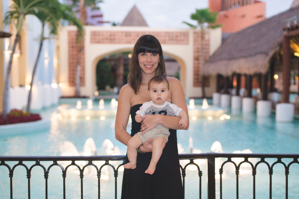 mom and baby boy by pool at all-inclusive resort in mexico