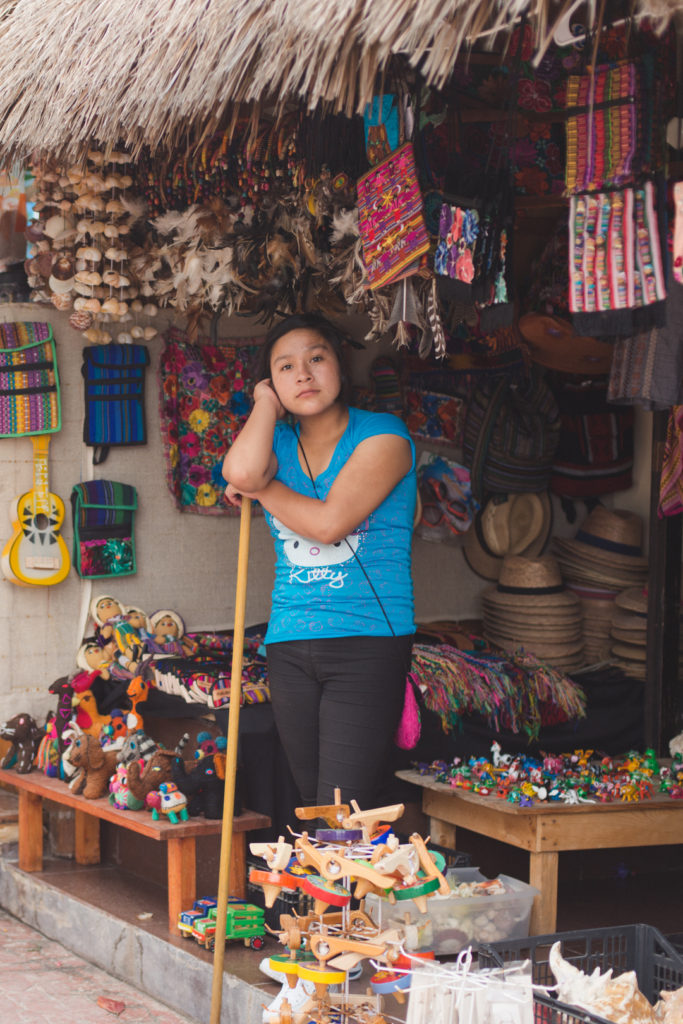 mexican girl standing at storefront of local shop in playa del carmen