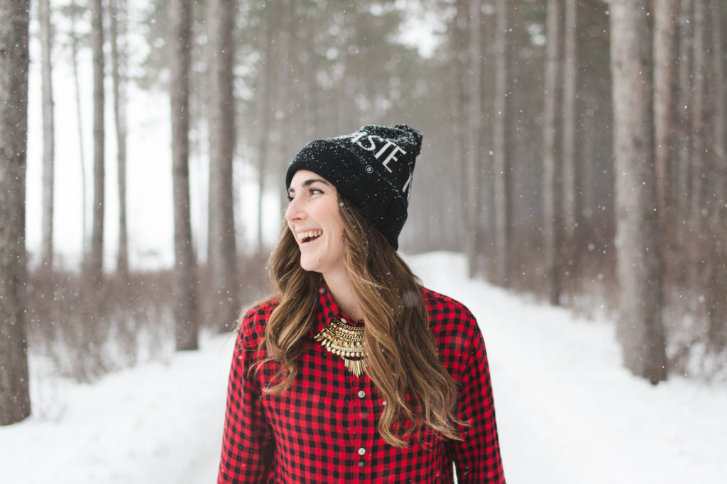 yoga instructor wearing "Namaste" toque on a snow covered path laughing