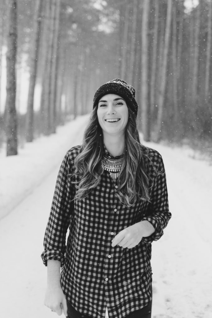 yoga instructor laughing as she walks along a snow covered path