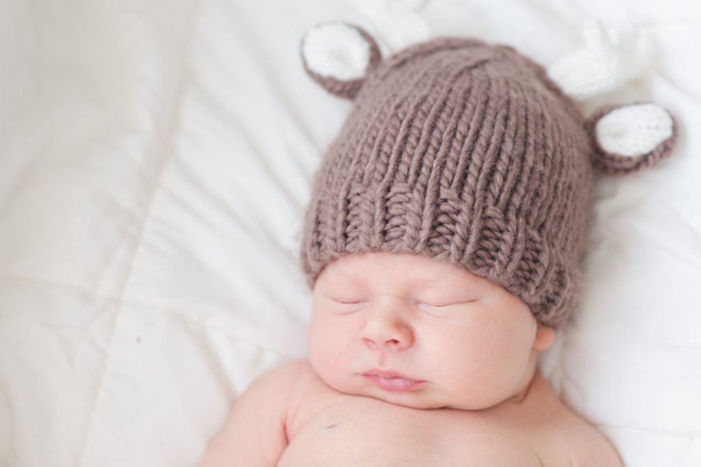 newborn baby boy wearing wool reindeer hat