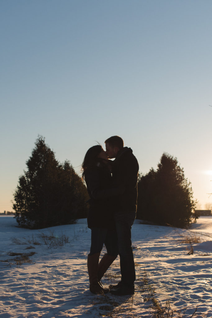 couple kissing at sunset on snowy path