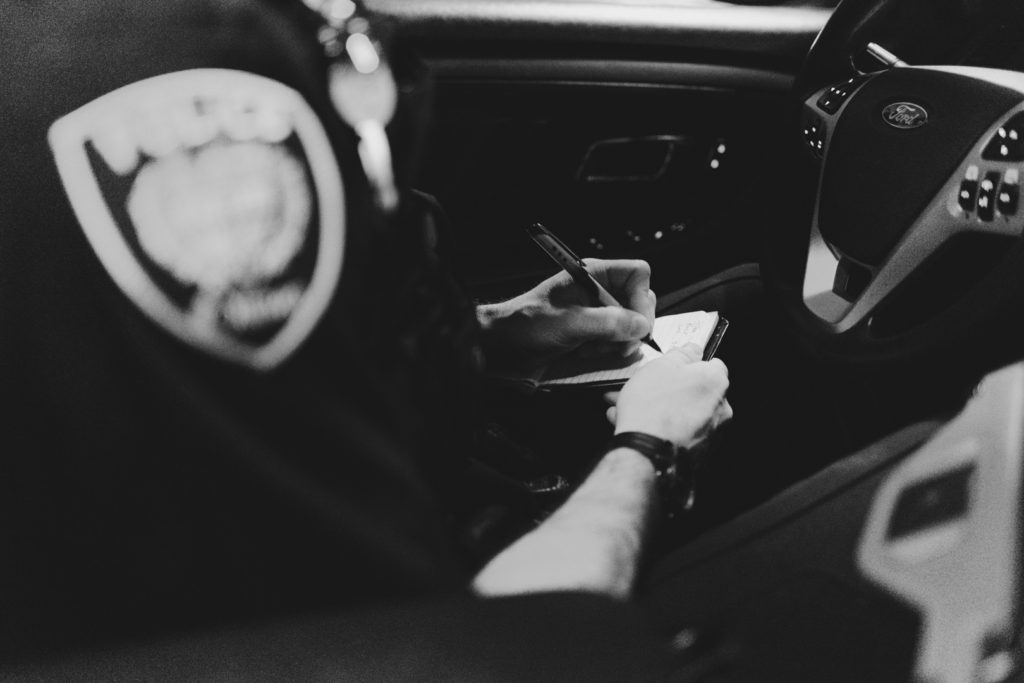 police officer taking notes on notepad in the police cruiser