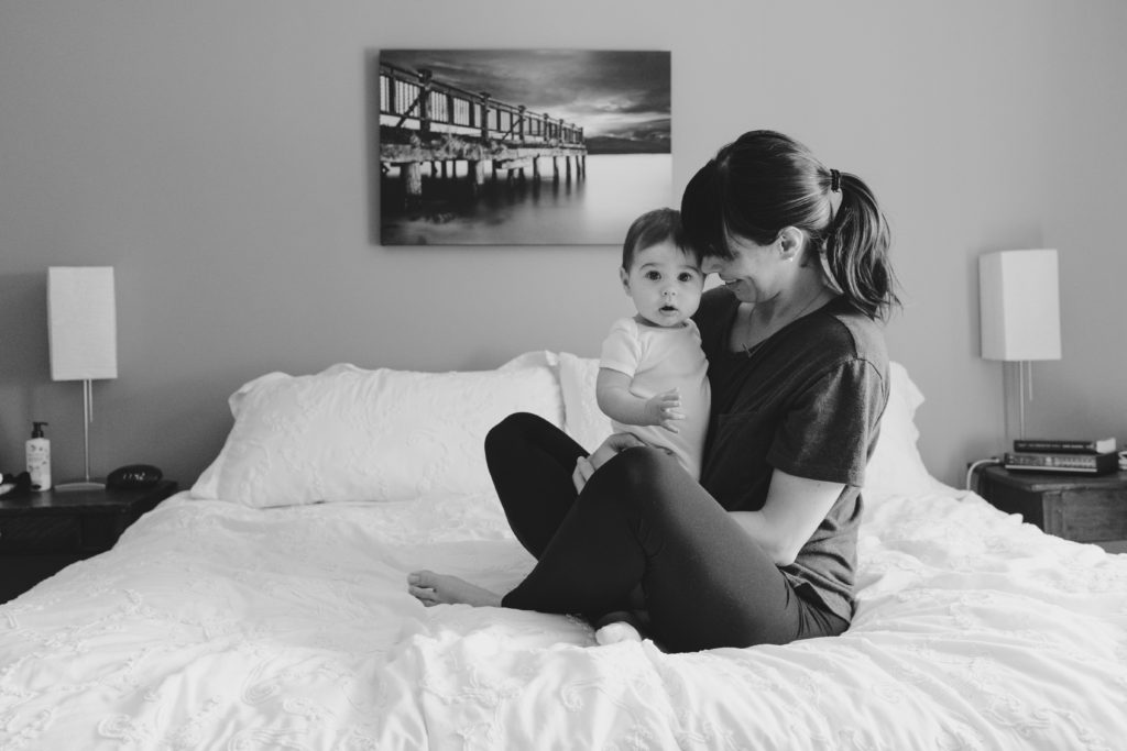 mom and baby cuddling on the bed in black and white