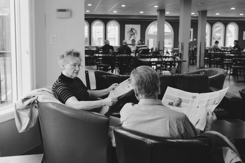 retired couple reading the paper at the coffee shop