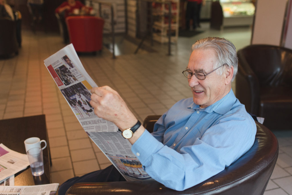 retired man reading the paper at the coffee shop