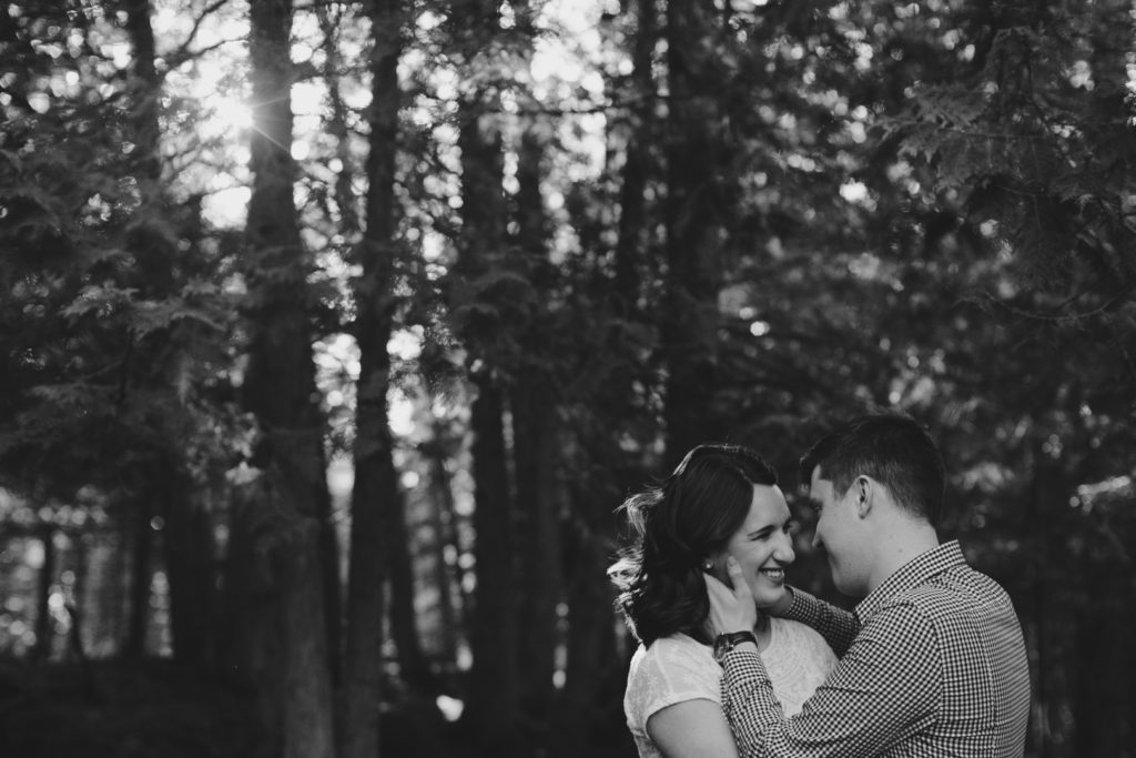 Couple standing in the woods together at sunset in black and white - Ashley Notley Photography