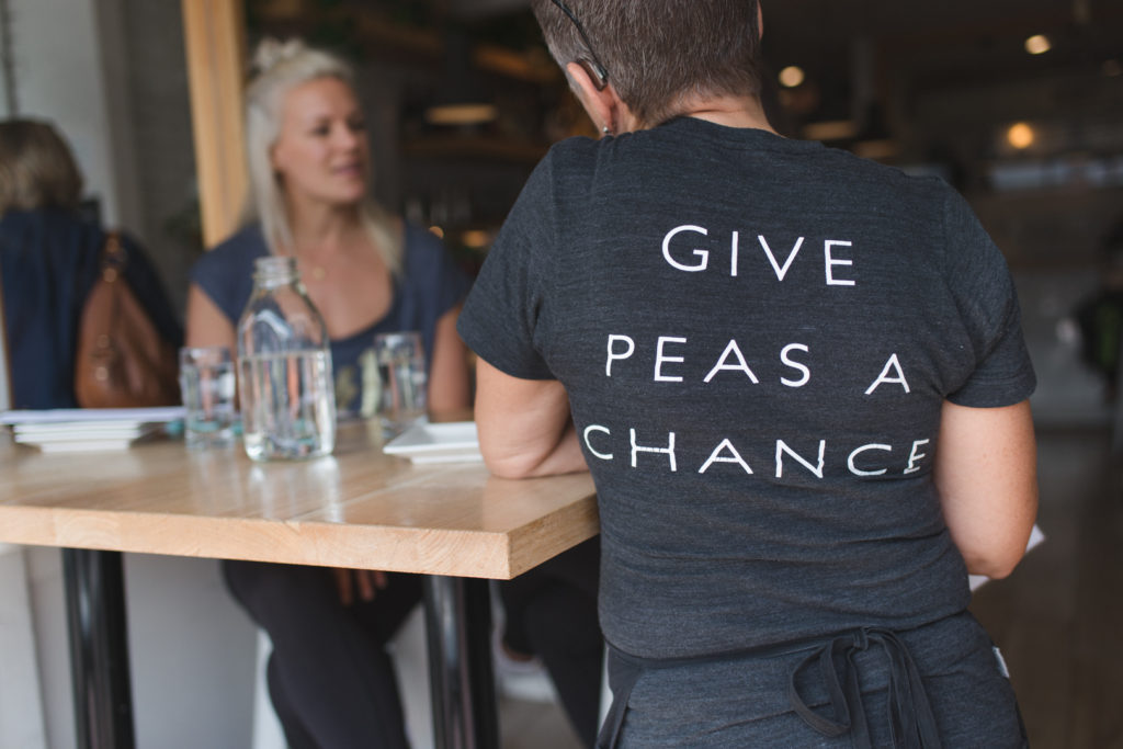 Server wearing Pure Kitchen t-shirt "Give peas a chance"