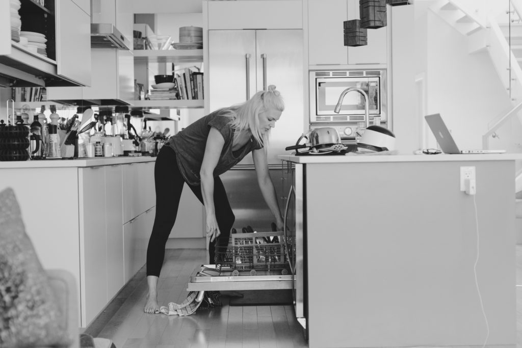 Amber Stratton emptying her dishwasher at home