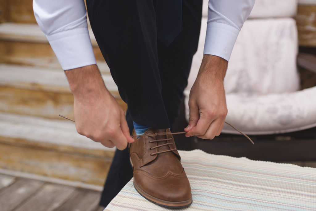 Groom tying up his shoes