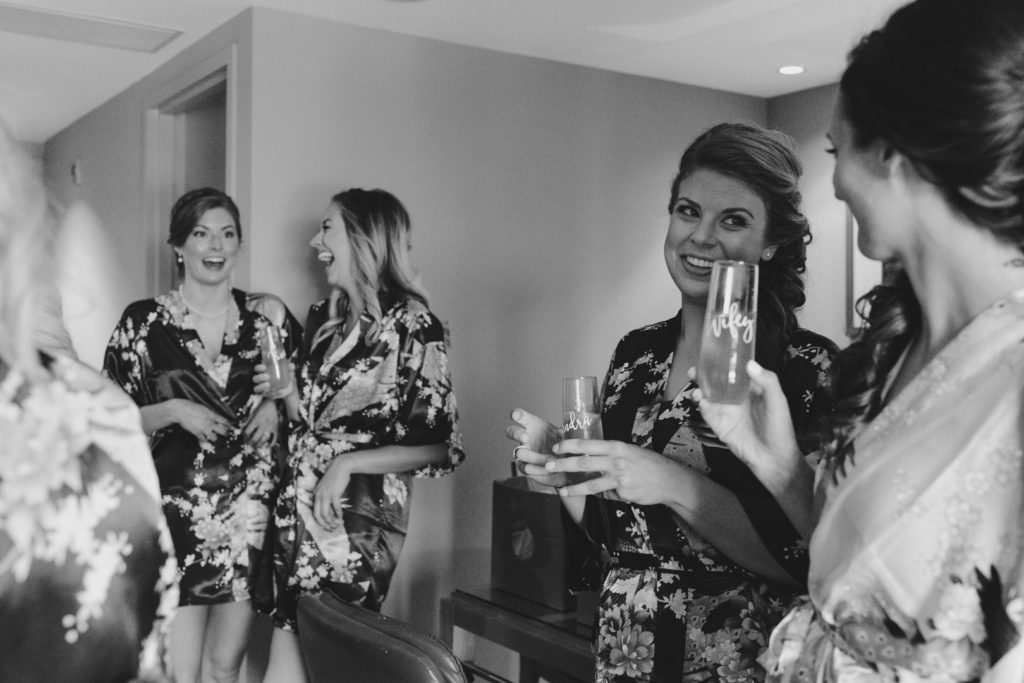 bridesmaids in floral robes drinking wine