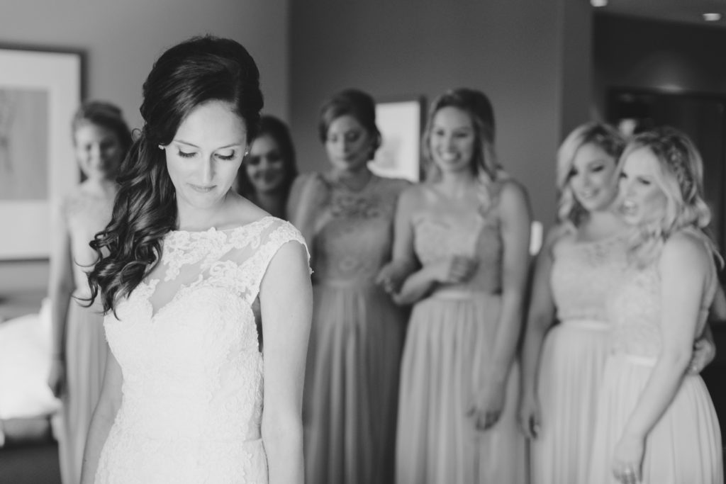 bridesmaids looking at bride in her dress for the first time
