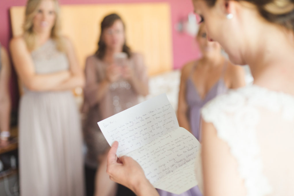 bride reading a letter from her groom on their wedding day