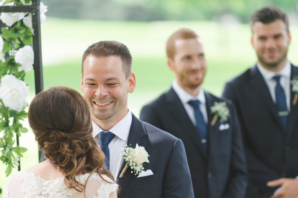groom smiling at his bride during the wedding ceremony