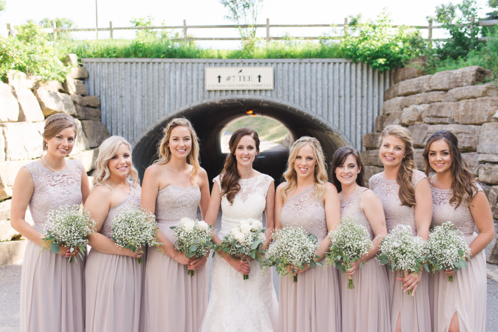 bride and bridesmaids in front of golf tunnel at marshes golf club