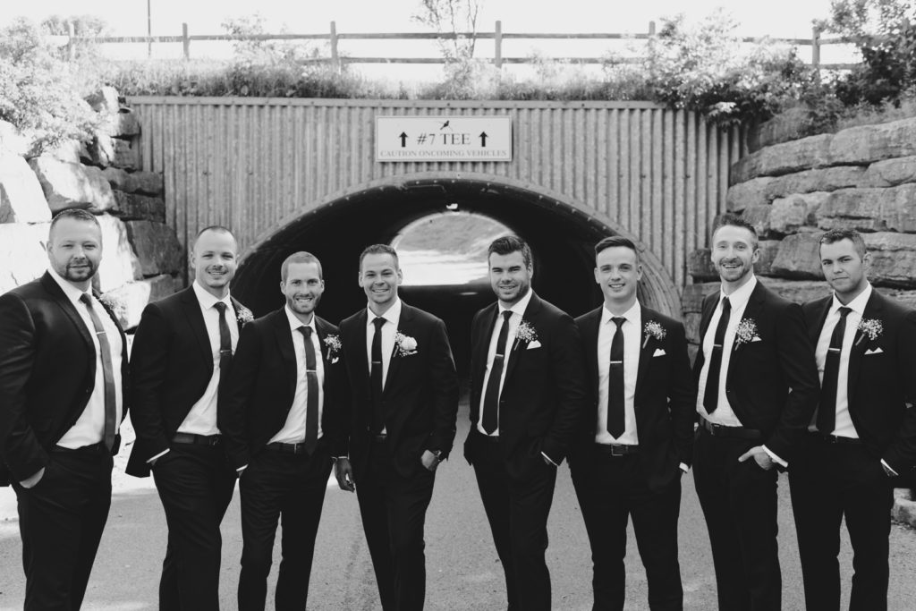 groomsmen in front of golf tunnel at marshes golf club