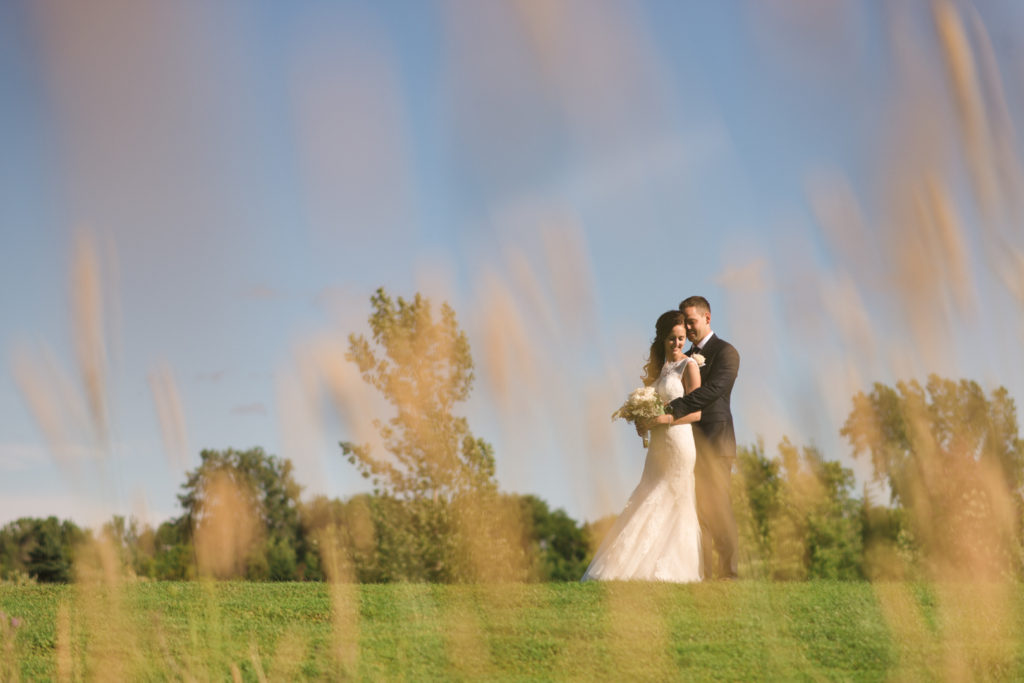bride and groom standing on golf green