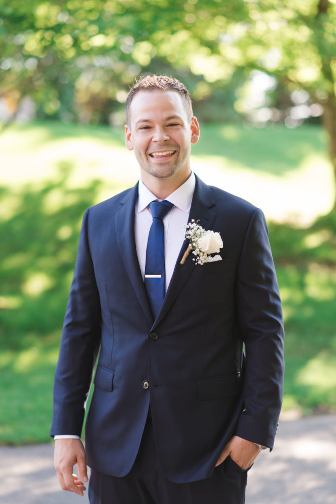 groom smiling with hand in pocket