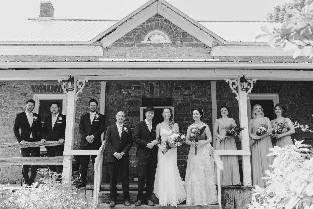 wedding party on the porch of a stone house