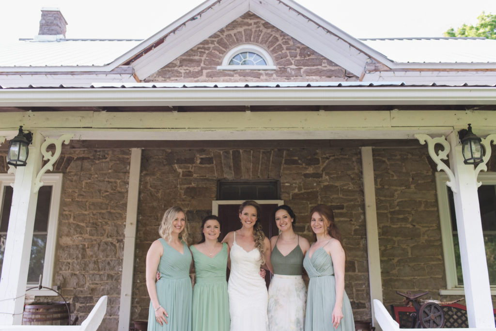 bridal party on the porch of a stone house