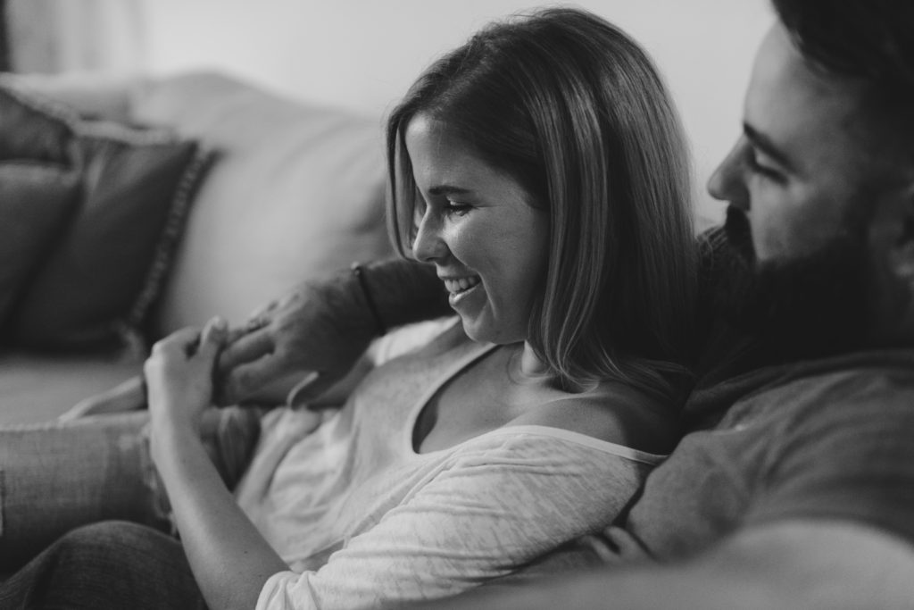black and white photo of couple cuddling on the couch