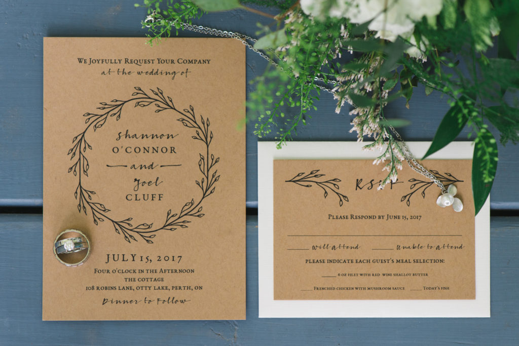 invitation suite in brown craft paper with green florals and rings