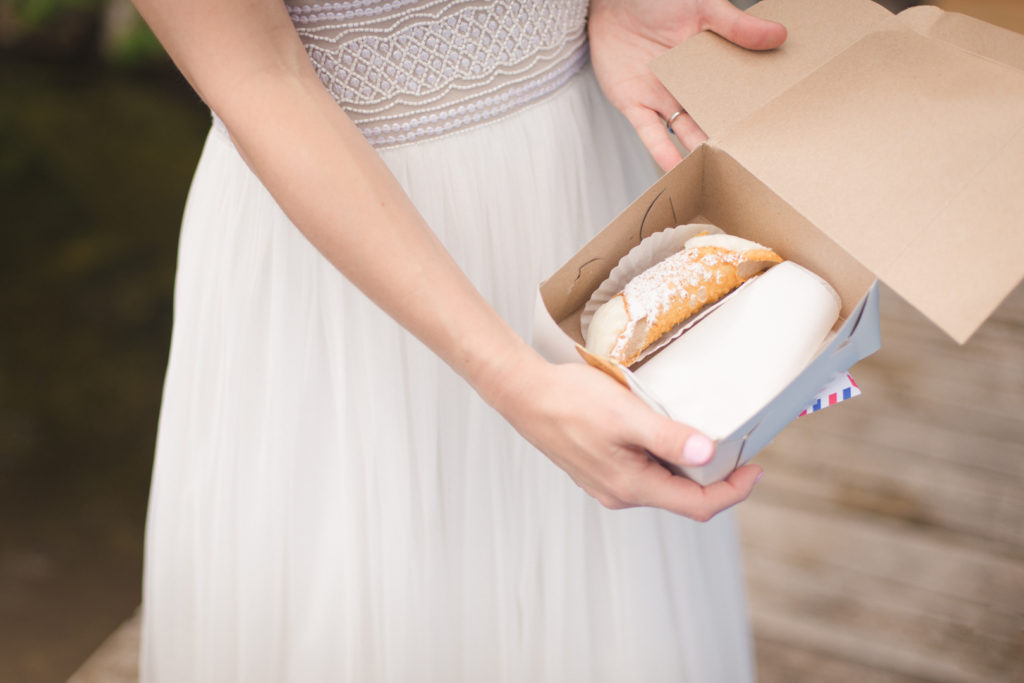 bride opening cannoli from her groom on their wedding day