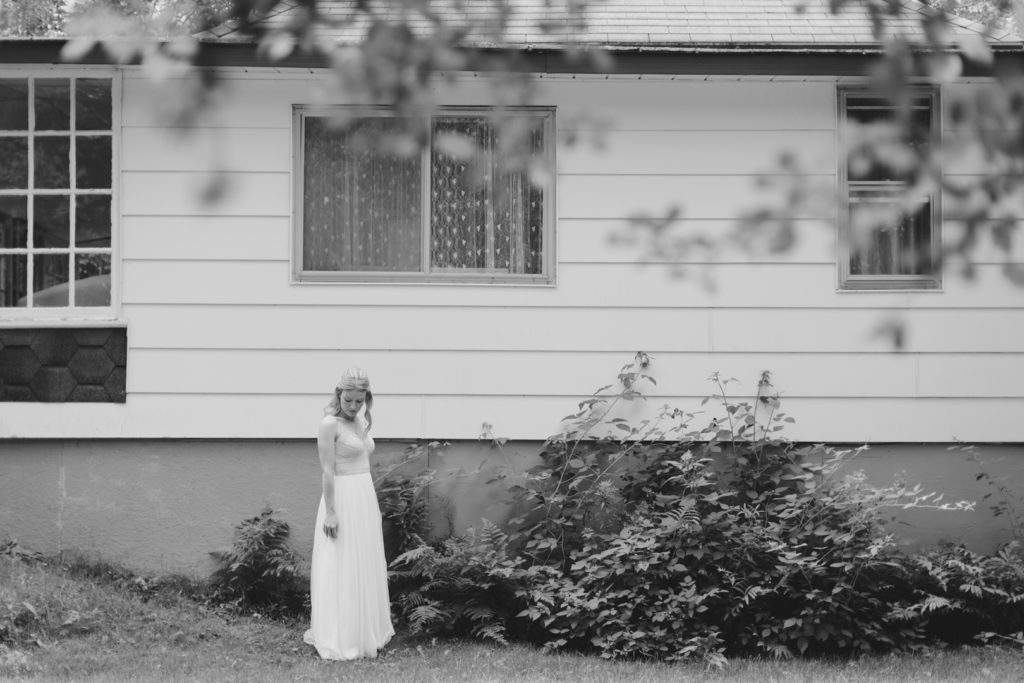 photo of bride in black and white standing outside old cottage