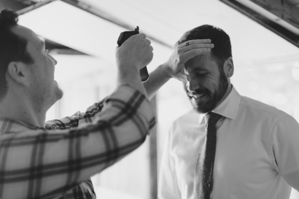 groom getting his hair done before wedding ceremony