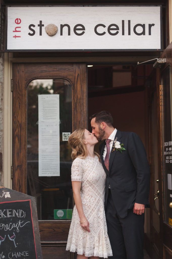 bride and groom kissing outside the stone cellar in perth ontario
