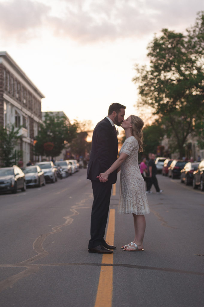 bride and groom kissing in the streets of Perth ontario at sunset