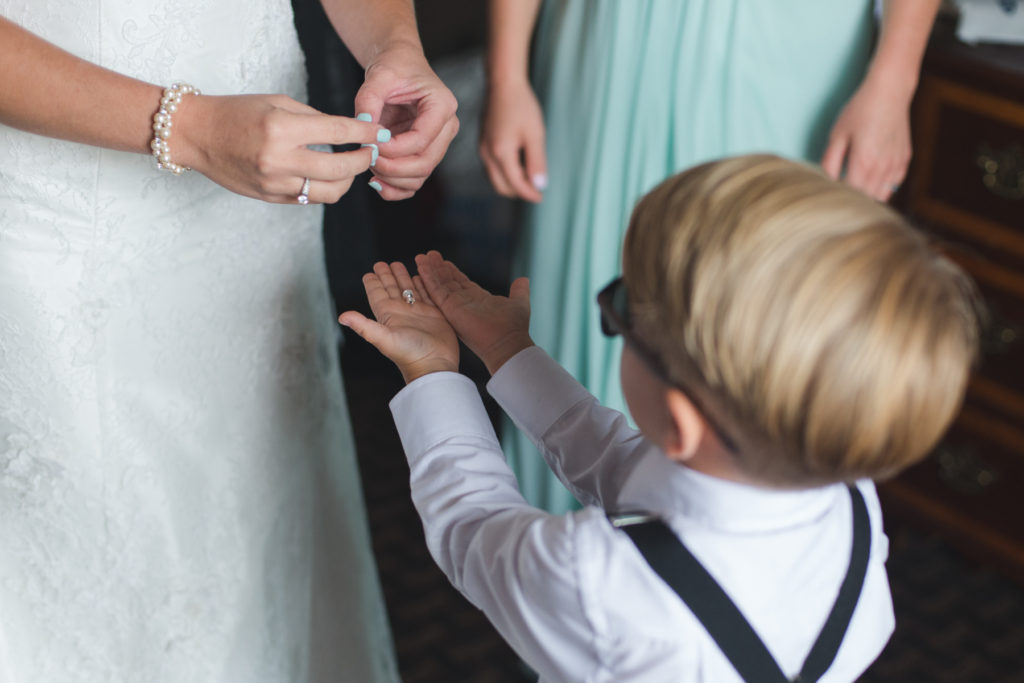 bride's son holding her jewellery out to his mom