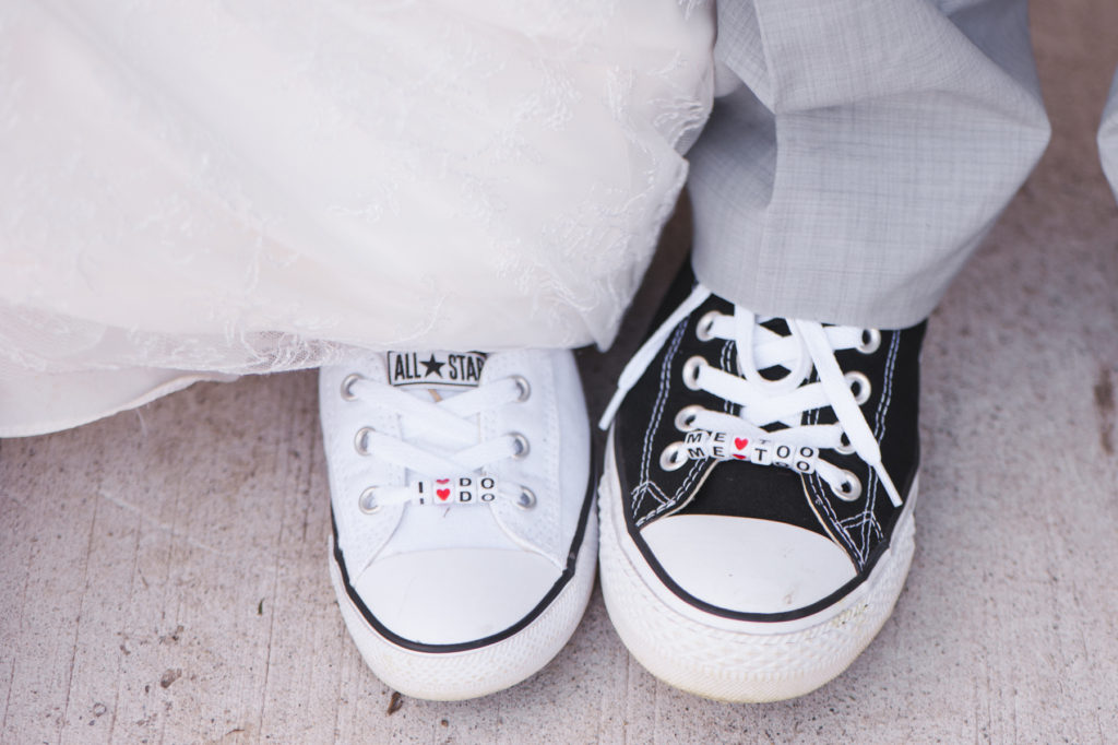 bride and groom wearing converse shoes that say "i do" and "me too"