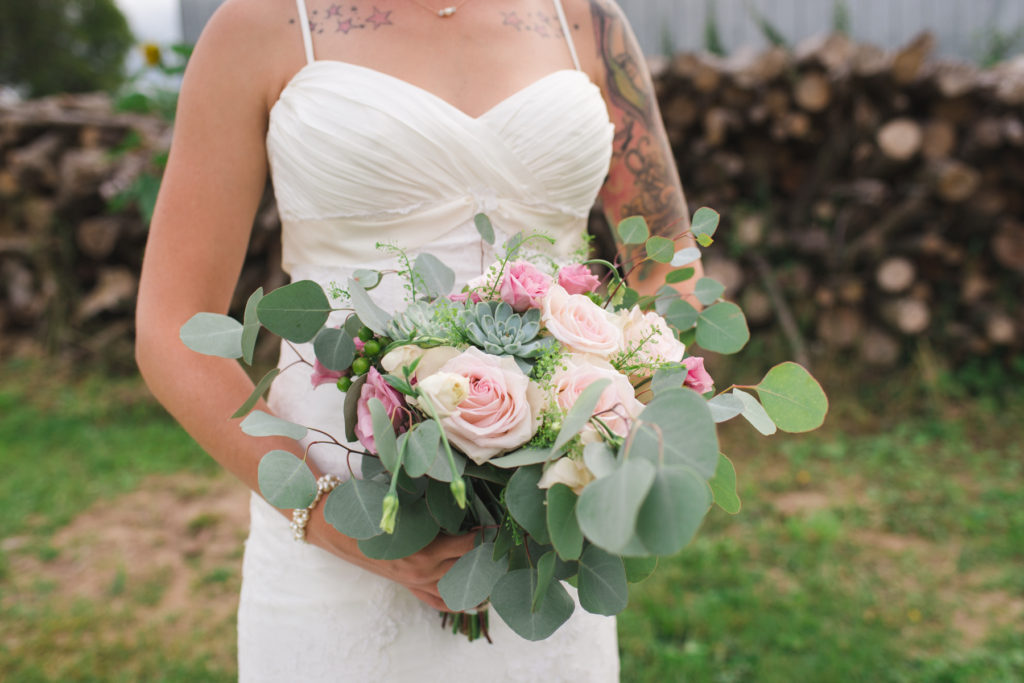 tattooed bride holding green and pink succulent bouquet