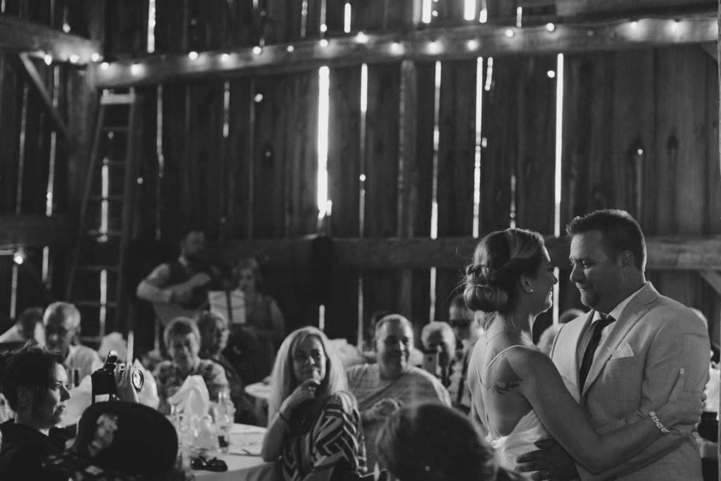 bride and groom first dance in old barn