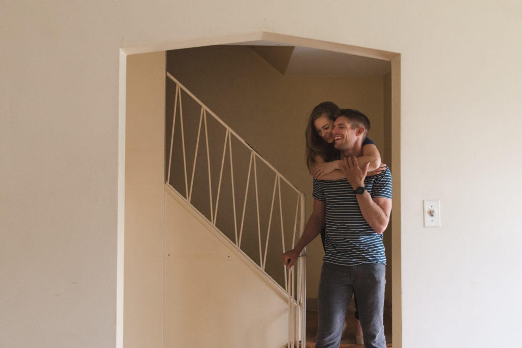 engaged couple cuddling on the stairs of their future home in Ottawa