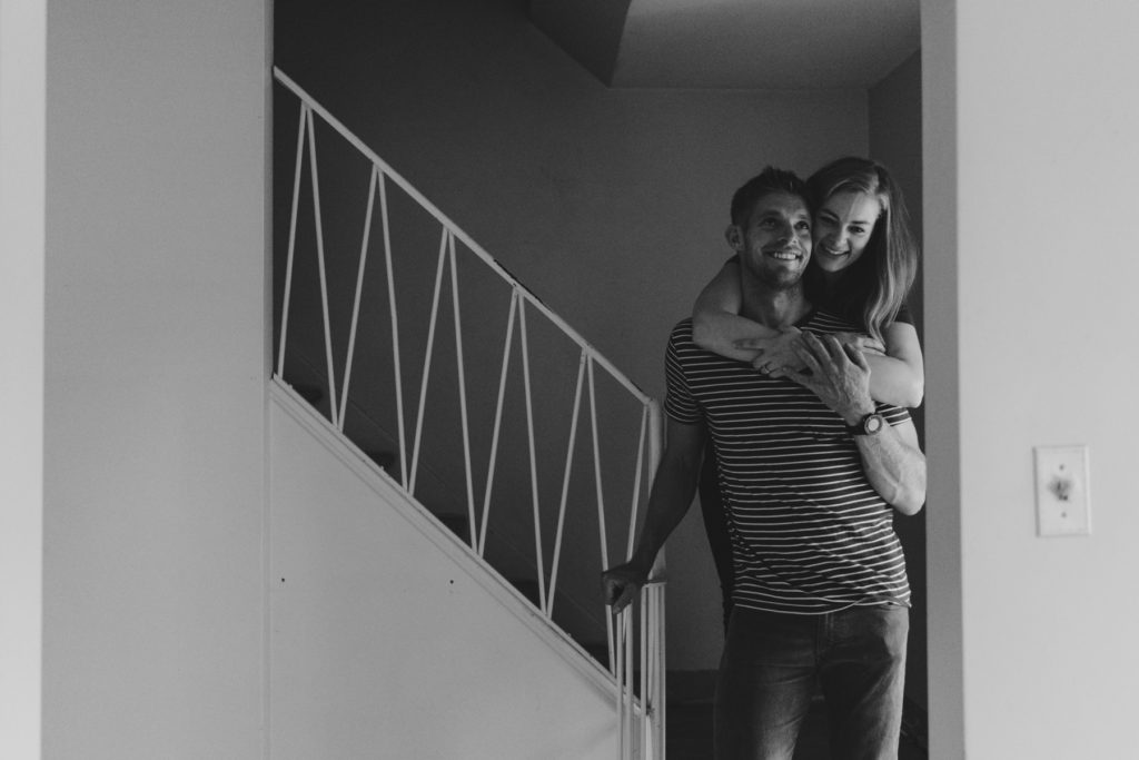 engaged couple cuddling on the stairs of their future home in Ottawa