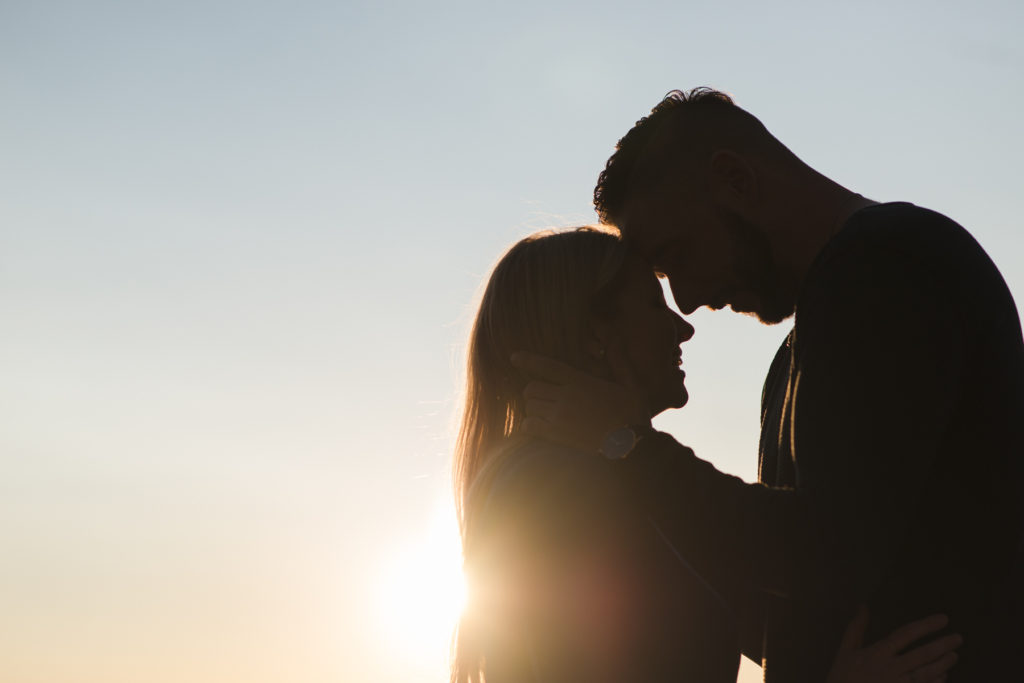 silhouette of engaged couple at sunset
