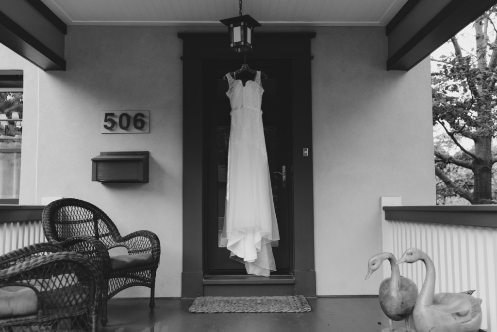 wedding dress hanging from front door at bride's home