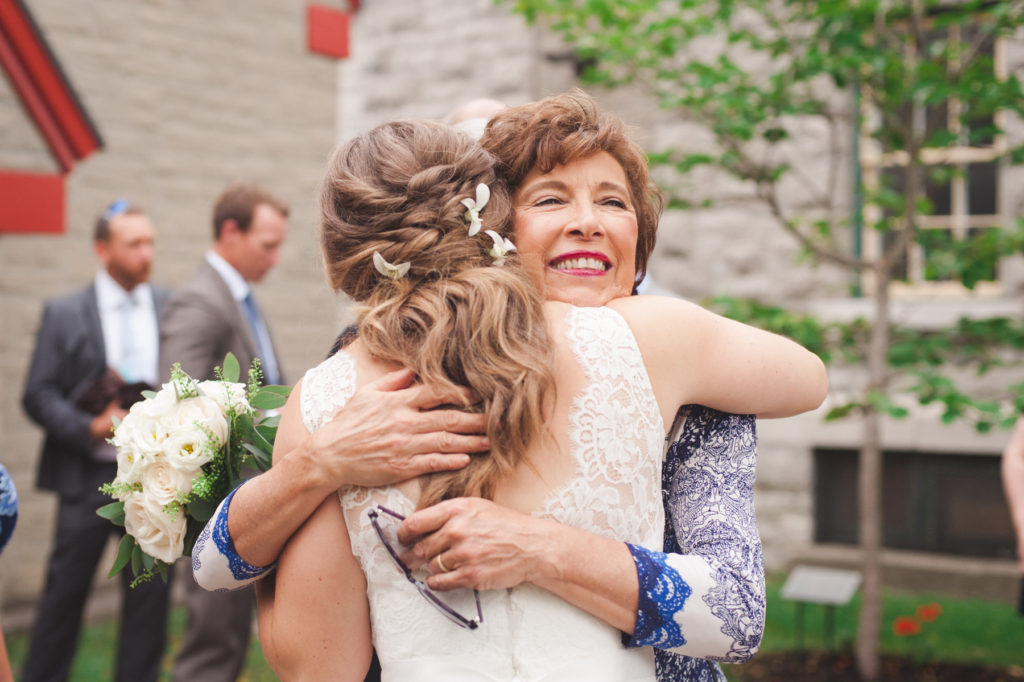 bride hugging her aunt outside of church following ceremony