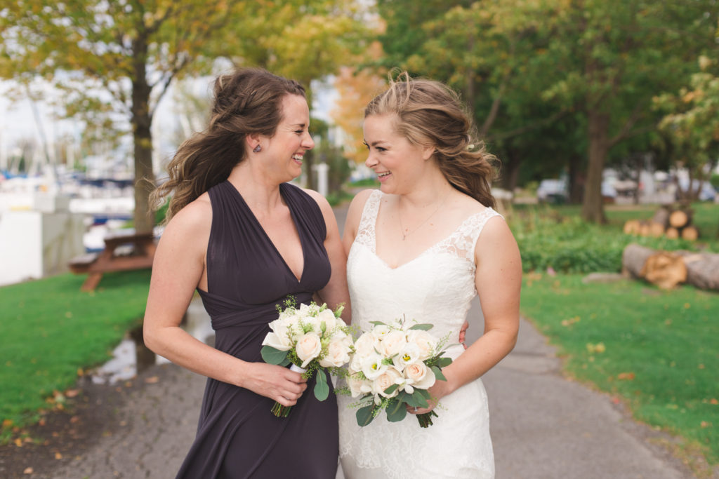 bride and maid of honour smiling at each other in the wind