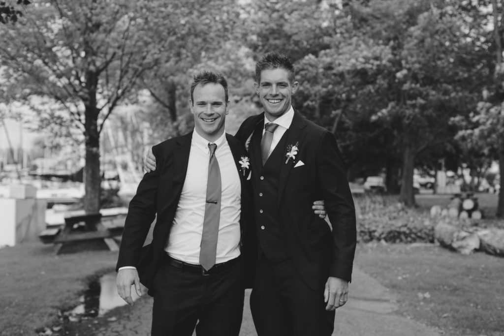 groom and best man smiling at the camera