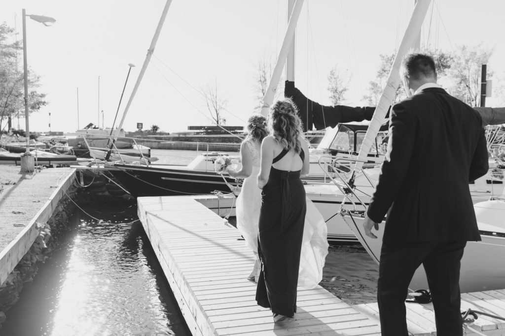 wedding party walking along yacht club docks