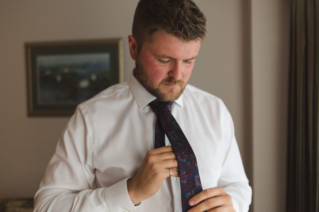 groom tying up his tie