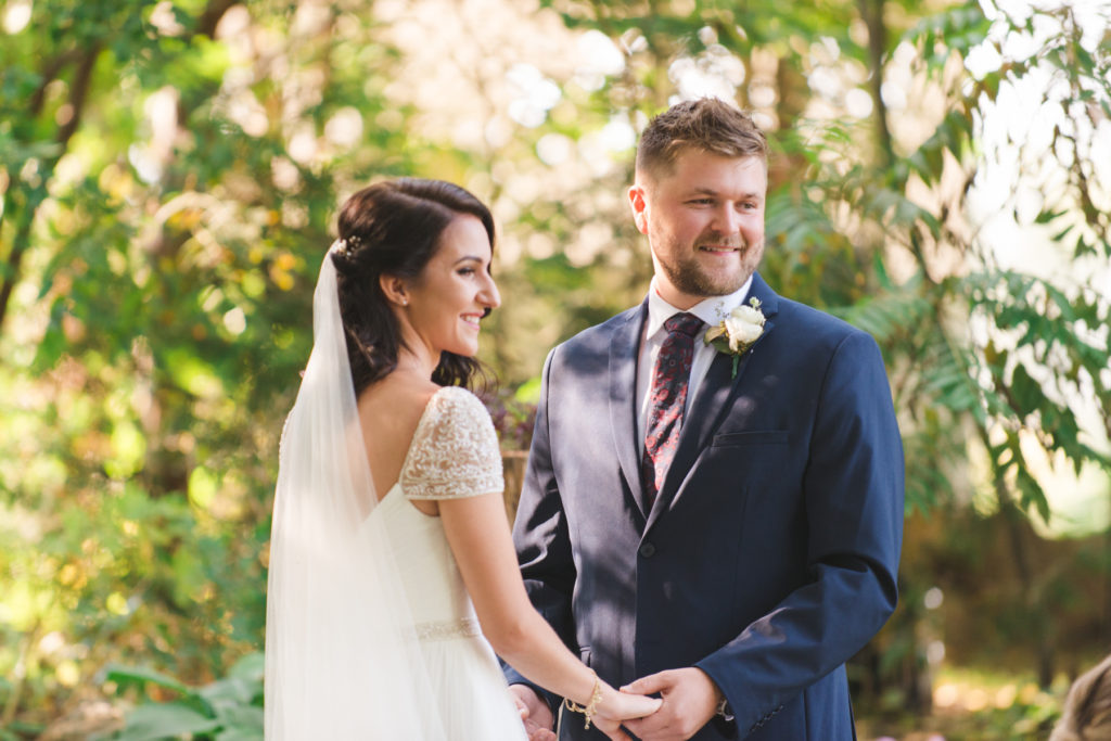 bride and groom smiling at their guests at ceremony