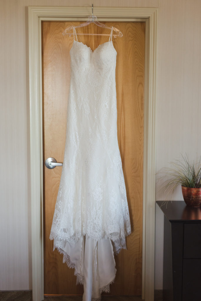 wedding dress hanging on wooden door